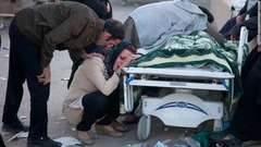 サルポールエザハブで地震の犠牲者の遺体に泣き崩れる人々＝１３日