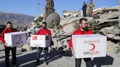 トルコの赤新月社のメンバーがダルバンディカンの被災者に支援物資を届ける様子＝１３日