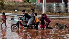 冠水した道路を進む人々