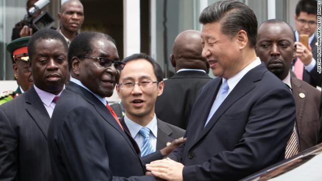 握手を交わすジンバブエのムガベ大統領（右）と中国の習近平国家主席