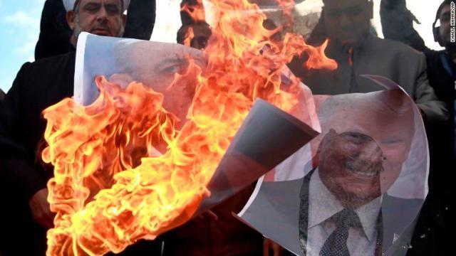 イスラエルのネタニヤフ首相と米国のトランプ大統領のポスターに火をつけて抗議する人たち＝７日