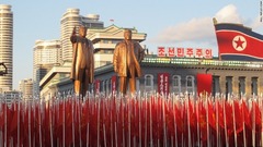 故金日成（キムイルソン）国家主席と故金正日（キムジョンイル）総書記の像の下を行進する北朝鮮軍兵士たち