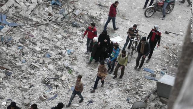 空爆後、損傷具合を調べるシリアの人々＝６日