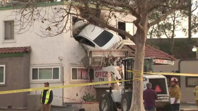 車が宙を飛び、建物の２階に激突した