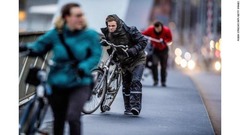 ロッテルダムでは強風のなか自転車を押して歩く人々