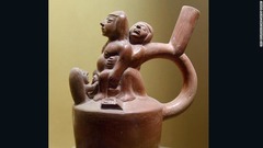 お産をする女性がモチーフの陶器。２人の人物に手助けしてもらっている