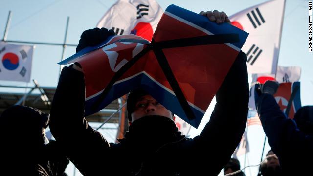 試合会場の外では、北朝鮮の旗を破って抗議する人の姿も