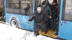 吹雪の中で慎重にバスを降りる乗客