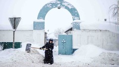 モスクワ郊外の村で雪かきをする修道女