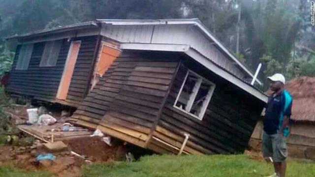 地震で破損した家屋を眺める男性＝２７日、パプアニューギニア・ヘラ州