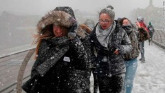 ミレニアム橋を渡る人々。雪の影響で学校は数百校が休校になった
