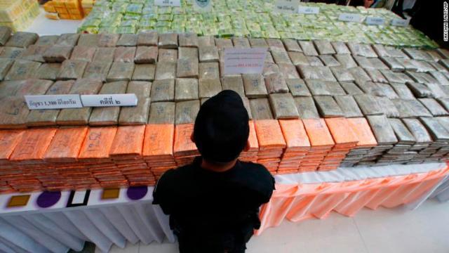 押収された膨大な量の薬物の前に立つタイの警察官