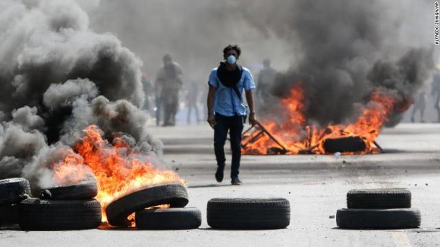 燃え盛るバリケードの間を歩くデモ参加者＝２０日、ニカラグア・マナグア