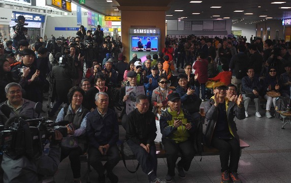 ソウルの駅構内で会談の中継映像を見守る人々