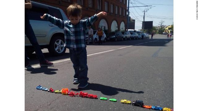 玩具の車で道路を「封鎖」する男の子