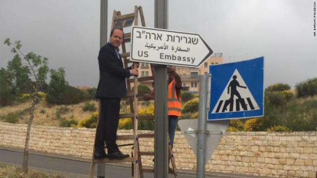 標識の横に立つエルサレム市長