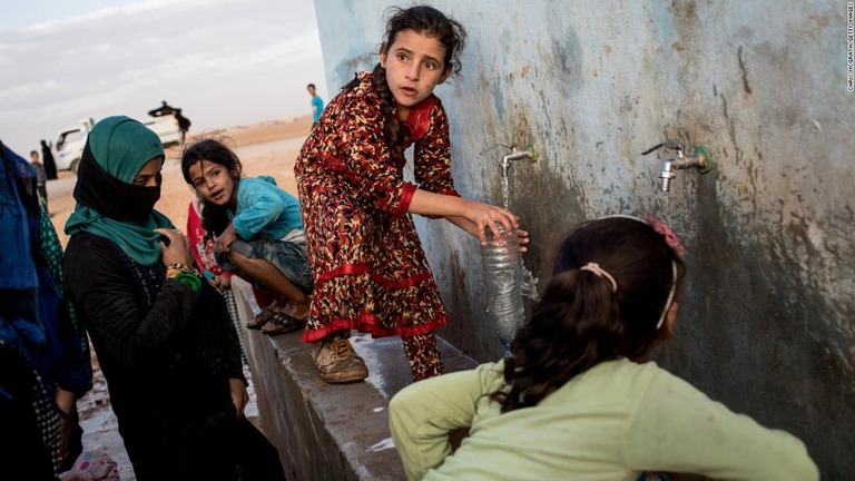 避難先でペットボトルに水を入れるシリアの少女。米政権はシリア北西部への支援の打ち切りを進めている