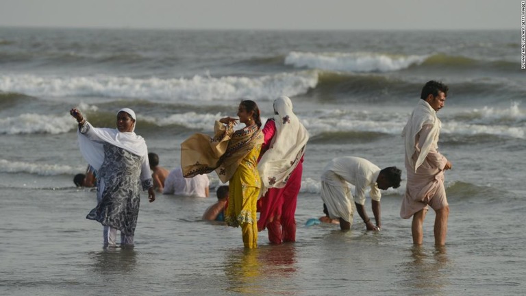 猛暑に見舞われる中、海辺で涼をとるカラチの住民