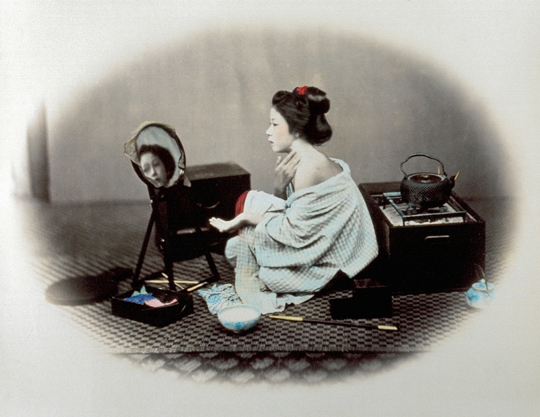 片方の肩を見せて白い化粧をする女性。官能的な画像は１９世紀末に多くの旅行客を日本に呼び寄せた＝Felice Beato
