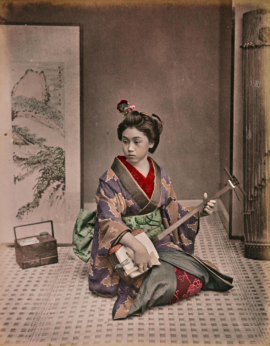 若い芸者が伝統的な楽器を奏でている=Kusakabe Kimbei
