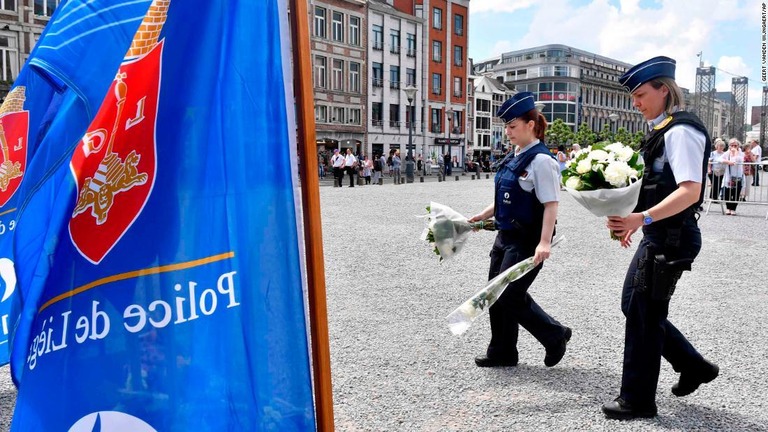 ３人が殺害された事件現場に献花する警察官