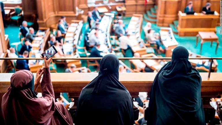 議会での様子を見るニカブを着た女性たち