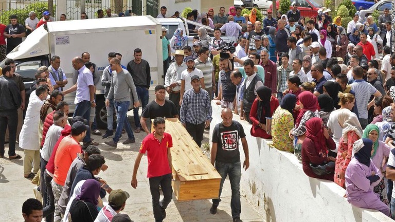 犠牲者の遺体を受け取るのを待つ人々＝チュニジア