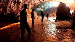 洞窟の入り口に排水ポンプを設置する救助隊＝７日