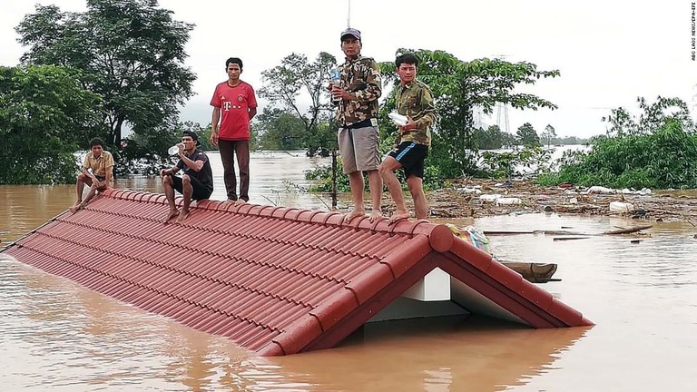 ダムの決壊を受けて、屋根の上に避難する人々＝２４日/ABC LAOS NEWS/EPA-EFE