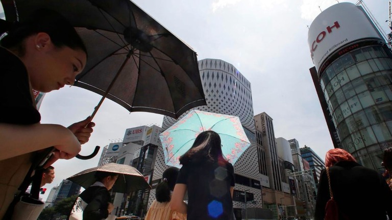 日傘をさす人たち＝２３日、東京/Koji Sasahara/AP