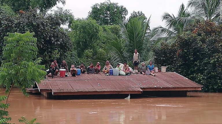 屋根の上に避難する人々＝２４日、アッタプー県/ABC LAOS NEWS/EPA-EFE