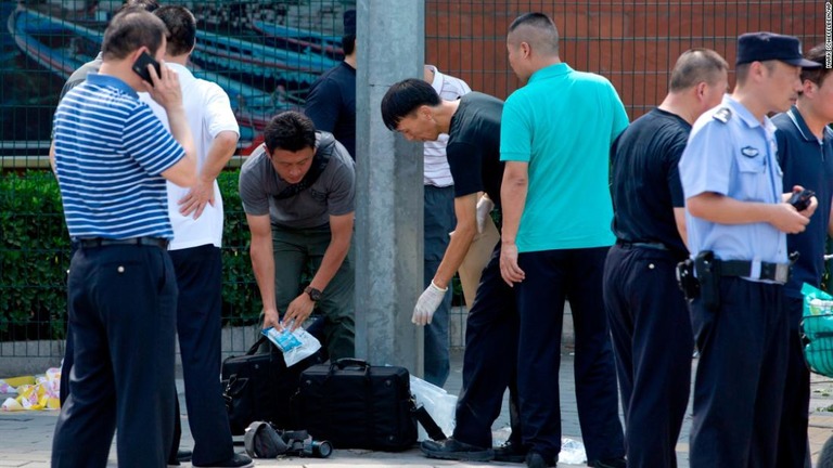 爆発現場とされる北京の米国大使館の南側付近に集まる中国の当局者ら＝２６日/Mark Schiefelbein/AP