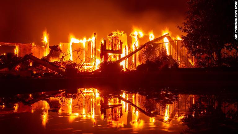 焼け落ちた家が水面に映る/JOSH EDELSON/AFP/Getty Images