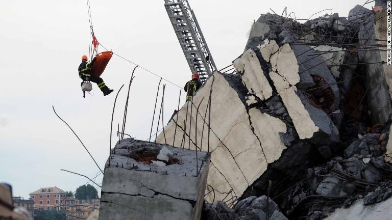 がれきの上で作業する救急隊員/Andrea Leoni/AFP/Getty Images