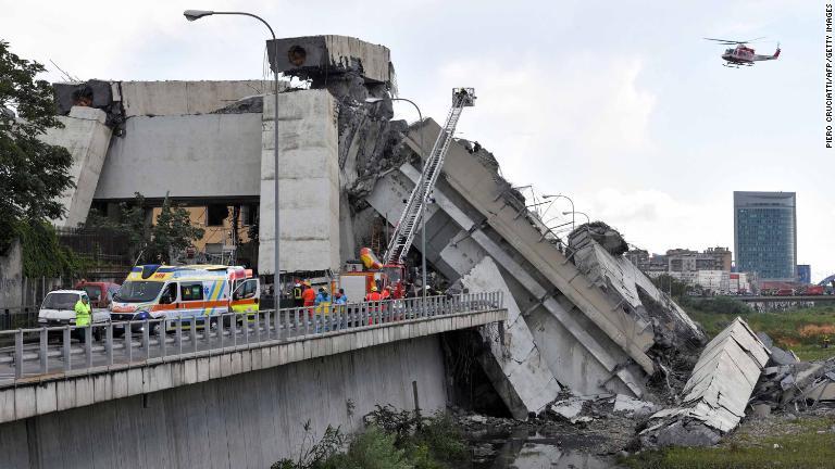 崩落した橋の上空を飛ぶヘリコプター/Piero Cruciatti/AFP/Getty Images