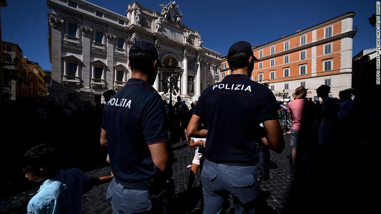 泉の周辺で人々の行動を監視するパトロール中の警官/FILIPPO MONTEFORTE/AFP/AFP/Getty Images