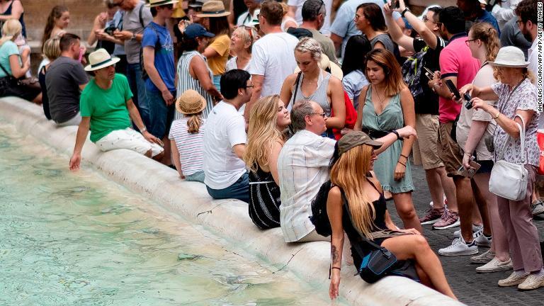 ほとんどの観光客はルールを守って水の中には入らないが、泉の中に入って違法な水浴びをする観光客もいる/ANDREAS SOLARO/AFP/AFP/Getty Images