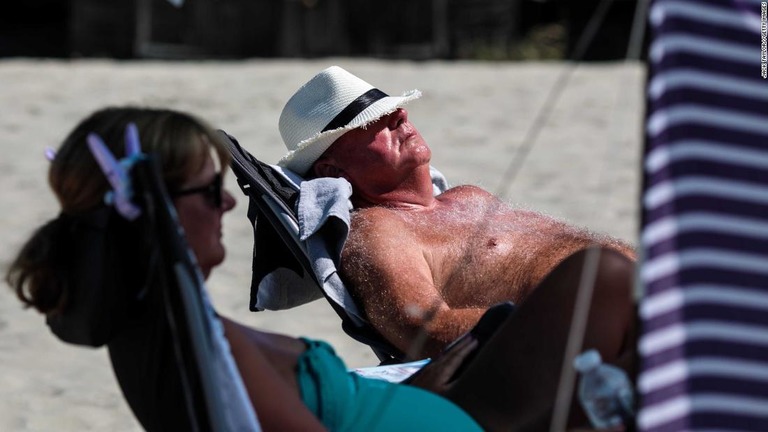 横になって日光を浴びる海水浴客＝７月２３日、イングランド・チチェスター/Jack Taylor//Getty Images