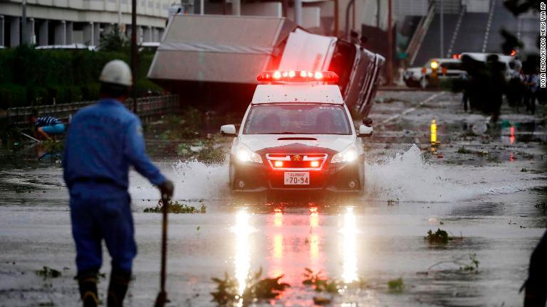 冠水した道路を行くパトカー/Kota Endo/Kyodo News via AP
