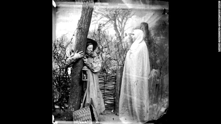 森に出現した幽霊を前にして樹にしがみつく男性/London Stereoscopic Company/Getty Images