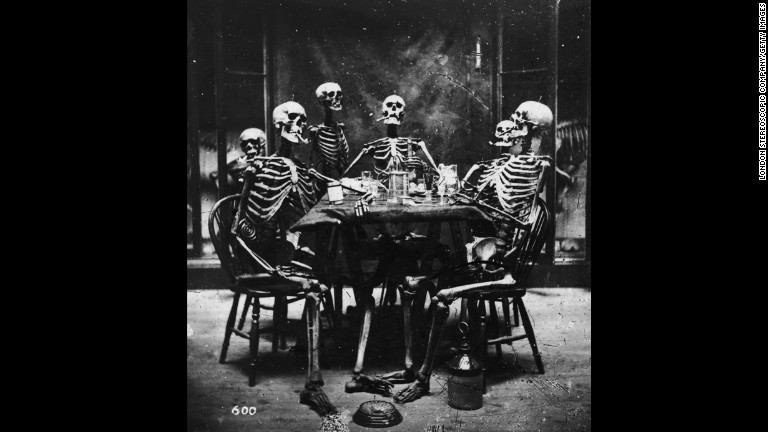 １８６４年作成のこの写真では、６体の骸骨が食卓を囲んで喫煙している/London Stereoscopic Company/Getty Images