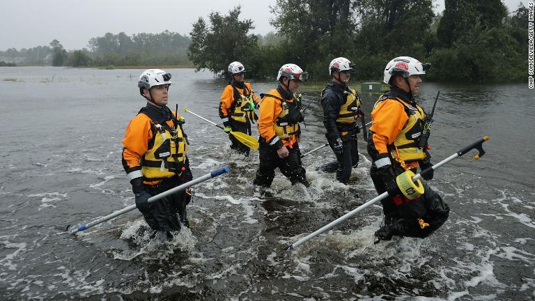 浸水した地域を捜索する当局者＝１４日/Chip Somodevilla/Getty Images
