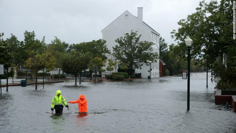 冠水した道路を歩く住民＝１３日、ノースカロライナ州/Chip Somodevilla/Getty Images