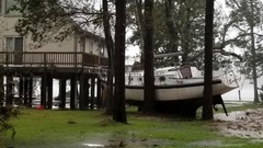 木々の間にはまりこんだボート＝１４日、ノースカロライナ州ニューバーン