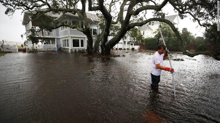 庭の排水管を探す男性＝１５日、ノースカロライナ州ウィルミントン/Mark Wilson/Getty Images