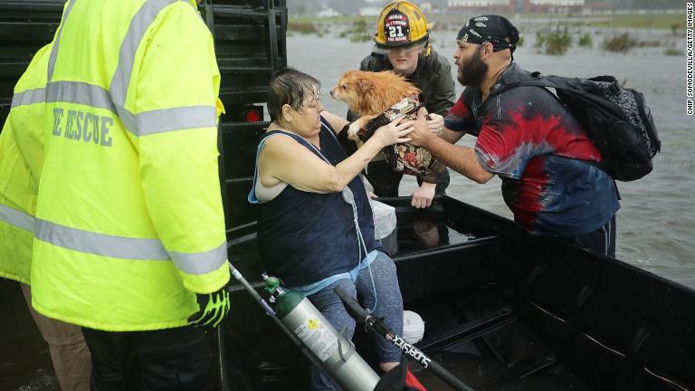 ペットとともに救助される女性＝１４日/Chip Somodevilla/Getty Images