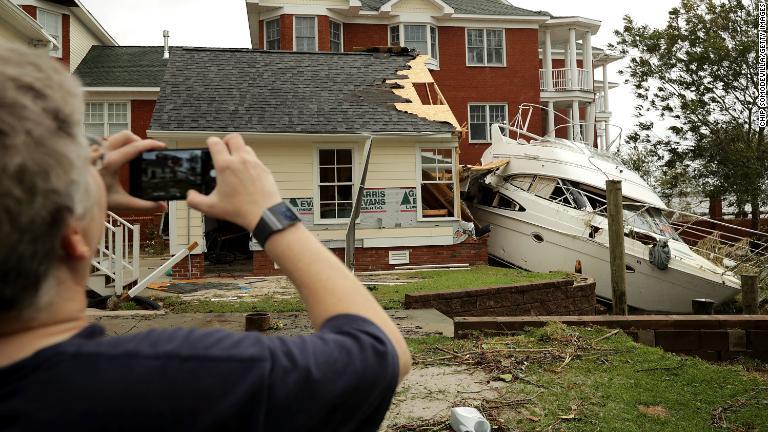 ガレージに突っ込んだボートの写真を撮る人＝１５日、ノースカロライナ州ニューバーン/Chip Somodevilla/Getty Images