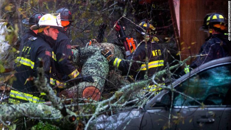 家屋に倒れた木を除去しようとする救急隊員＝１４日/Jim Lo Scalzo/EPA/Shutterstock