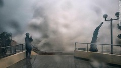 高波の様子を撮影する男性＝１６日、香港