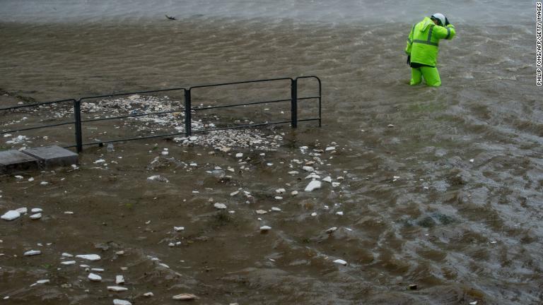 洪水のなかを歩く警備員＝香港/Philip Fong/AFP/Getty Images